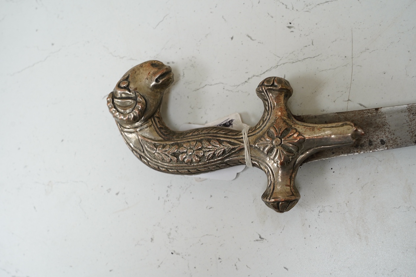 A decorative Indian sword, Shamshir hilt of embossed silver plated copper with a rams head pommel, blade 73.5cm. Condition - good